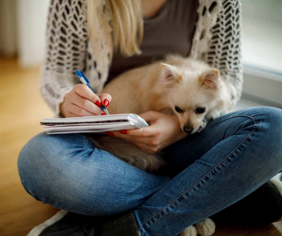 Woman writing with Pomeranian